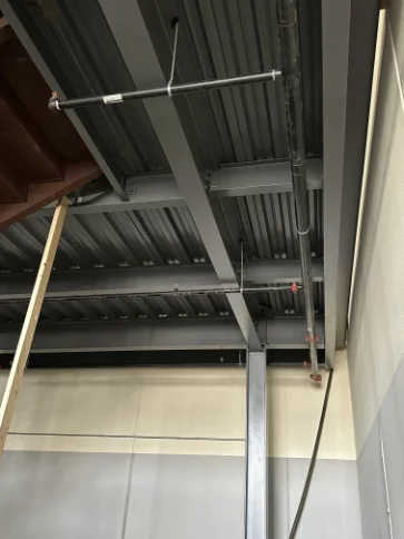 Secondary overhead fire sprinkler branch piping secured to structural steel decking.